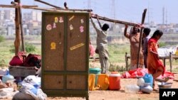 People displaced by the flooding in Pakistan prepare to set a tent at a makeshift camp on the outskirts of Hyderabad, Sindh province, Sept. 2, 2022.