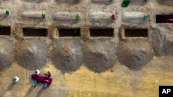 Pogrebnici nose sanduk sa tijelom neidentifikovanog civila koji je ubijen u Buči, u vrijeme ruske okupacije februar-mart 2022, tokom sahrane u Buči, nedaleko od Kijeva.