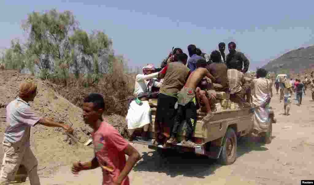 People sit on boxes of&nbsp;ammunition looted from an army depot in Aden, March 27, 2015.