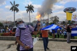 An anti-government protester fires a homemade mortar on the sidelines of a Stations of the Cross procession on Good Friday in Managua, Nicaragua, April 19, 2019.