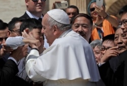 Pope Francis kisses a child with a group of faithful from Shanghai during his weekly general audience in St. Peter's square at the Vatican, May 22, 2019.