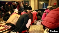 Police conduct a head count of suspects who were detained during a police raid, as part of plans to crackdown on prostitution, at a hotel in Dongguan, Guangdong province, Feb. 9, 2014.