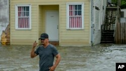 Beri Vilijams korača kroz poplavljenu ulicu pored jezera Pončatrejn