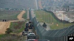 FILE - A motorcade carrying President Donald Trump drives along the border in San Diego, March 13, 2018.