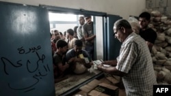 Pengungsi Palestina di kamp Jabalia menerima pembagian makanan bantuan PBB di Jalur Gaza utara (foto: dok). 