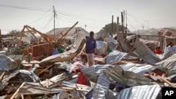 A shopkeeper surveys the wreckage of shops destroyed by a blast in a market in the capital Mogadishu, Somalia, Feb. 19, 2017.