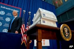 FILE - President Donald Trump arrives to speak about infrastructure at the Department of Transportation in Washington, June 9, 2017.