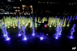 Children cool themselves off in a public water fountain in downtown Seoul, South Korea, July 23, 2018.