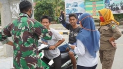 Petugas menasehati pengendara sepeda motor yang tidak menggunakan masker dalam diantara pelaksanaan PSBB di Buol, Sulteng, 14 Mei 2020. (Foto: Diskominfo Buol)