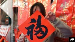 A woman holds a traditional decoration with Chinese character 'Fu,' meaning 'good fortune' at the Dihua Street market in Taipei, Jan. 20, 2023.