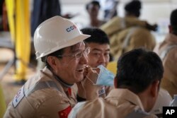 Chinese workers from China Oilfield Services Limited (COSL) begin drilling at the Kingfisher oil field on the shores of Lake Albert in the Kikuube district of western Uganda Tuesday, Jan. 24, 2023. (AP Photo/Hajarah Nalwadda)