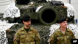 Denmark's military officers stand next to a Leopard 2A7 tank at the Tapa Military Camp, in Estonia, Jan. 19, 2023.
