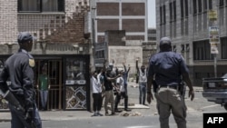 Des agents des services de police sud-africains (SAPS) en patrouille dans le quartier central des affaires de Johannesburg lors des troubles du 16 janvier 2023,