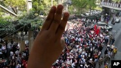 Myanmar nationals living in Thailand display the three-finger symbol of resistance during a protest marking the anniversary of the military takeover that ousted their government outside the Myanmar Embassy in Bangkok, Thailand, Feb. 1, 2023.