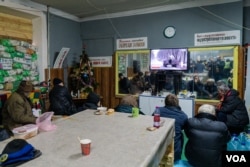 2023年1月20日，在炮弹纷飞之际，当地居民在巴赫穆特的 一处地堡观看电视。(美国之音博夏特拍摄)