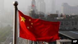 Bendera nasional China berkibar di gedung perkantoran di Shanghai, China. (Foto: AP)