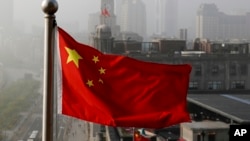 Bendera nasional China berkibar di gedung perkantoran di Shanghai, China. (Foto: AP)