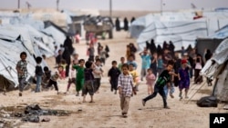 Anak-anak berkumpul di luar tenda mereka, di kamp al-Hol, yang menampung keluarga anggota kelompok militan ISIS di provinsi Hasakeh, Suriah (foto: dok). 