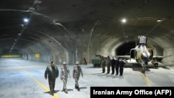 A picture provided by the Iranian Army Office shows Commander-in-Chief of the Iranian Army Major General Abdolrahim Mousavi, right, and Armed Forces Chief of Staff Major General Mohammad Bagheri, center, at Iran's first underground military air base in an undisclosed location.