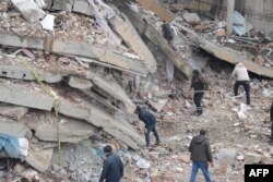 Petugas penyelamat dan sukarelawan melakukan operasi pencarian dan penyelamatan di reruntuhan bangunan di Diyarbakir, 6 Februari 2023.