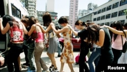 资料照：香港警方把一队被指在港卖淫的大陆性工作者押上警车。（2002年9月19日）