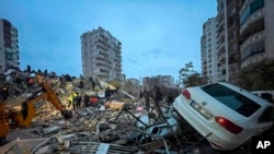 Emergency teams search for people in a destroyed building in Adana, Turkey, Feb. 6, 2023. 