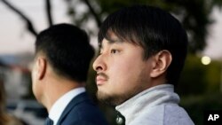 Brandon Tsay, right, and his father, Tom Tsay, make a statement outside their home, Jan. 23, 2023, in San Marino, California. Brandon disarmed a gunman responsible for killing multiple people in Monterey Park.
