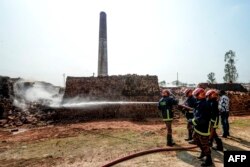 FILE - Firefighters spray water over a brick kiln on the outskirts of Dhaka, Bangladesh, Dec. 4, 2019. Journalist Abu Azad says he was kidnapped and beaten in December 2022 for investigating illegal brick kilns in the country.
