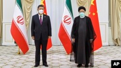 FILE - In this photo released by China's Xinhua News Agency, Iran's President Ebrahim Raisi, right, and Chinese President Xi Jinping pose for a photo on the sidelines of the Shanghai Cooperation Organization (SCO) summit in Samarkand, Uzbekistan, Sept. 16, 2022.