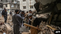 Polisi berpakaian preman berkumpul di atas puing-puing masjid yang rusak setelah ledakan bunuh diri pada 30 Januari di Peshawar pada 1 Februari 2023. (Foto: AFP)