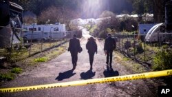 FBI officials walk toward the crime scene at Mountain Mushroom Farm, Jan. 24, 2023, after a gunman killed seven people at two agricultural businesses in Half Moon Bay, California.
