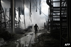 A Ukrainian firefighter walks amid rubble in a shopping mall following a Russian shelling in Kherson, amid the Russian invasion of Ukraine.