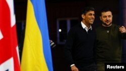 Ukraine's President Volodymyr Zelenskyy and British Prime Minister Rishi Sunak walk, as they hold a news conference at an army camp, in Dorset county, Britain, Feb. 8, 2023. 