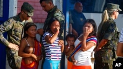 Yanomami Indigenous people stand outside the Health Indigenous House, a center responsible for supporting and assisting Indigenous people in Boa Vista, Roraima state, Brazil, Feb. 8, 2023.