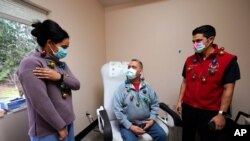 FILE - Volunteers prepare donations for delivery to those affected by COVID-19 on tribal lands June 25, 2020, in Tempe, Ariz. 