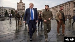 FILE - In this image provided by the Ukrainian Presidential Press Office, Ukrainian President Volodymyr Zelenskyy, center right, and Britain's Prime Minister Boris Johnson, center left, walk during Johnson's visit, in Kyiv, Ukraine, April 9, 2022.
