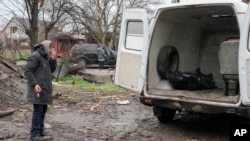 Žena plače pored tela bližnjeg ubijenog u ruskom vazdušnom udaru na početku rata u Ukrajini, u Bodorjanki, nedaleko od Kijeva, 9. aprila 2022.