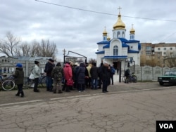 Residents wait near a church for humanitarian aid, in Borodyanka, Ukraine, April 6, 2022. (Heather Murdock/VOA)