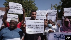 FILE - Sudanese journalists protest in Khartoum, Sudan, Nov.16, 2021. Many of the placards read: "We stand with the masses against the military coup." 