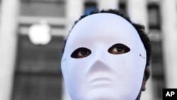 Nati Reyes joins other protesters to stage a mock 'Uighur forced labor camp' outside the flagship Apple store, March 4, 2022, in Washington, to highlight the alleged use of illegal forced Uighur labor in its supply chain. 