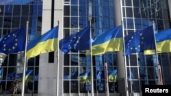 Bendera Uni Eropa dan Ukraina berkibar di luar gedung Parlemen Eropa, di Brussel, Belgia, 28 Februari 2022. (Foto: Reuters)