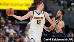 Nikola Jokić u duelu sa Kajlom Andersonom iz Memfisa, u Denveru, 7. aprila 2022. (Foto: AP/David Zalubowski)