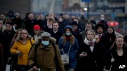 Para pekerja berjalan menuju jembatan London pada jam-jam sibuk pagi hari di London, di tengah meningkatnya kasus COVID-19 di Inggris (foto: ilustrasi). 