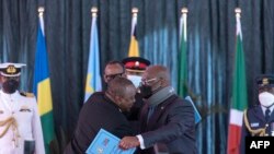 Rais Uhuru Kenyatta na Rais wa DRC Felix Tshisekedi wakikumbatiana baada ya kusainiwa mkataba unaoiruhusu DRC kuwa mwanachama wa EAC, Nairobi, April 8, 2022. Picha ya AFP