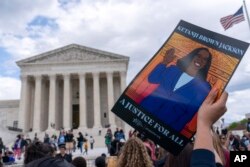 មនុស្សម្នានាំគ្នាអបអរសាទរការអនុម័តតាំងតែងចៅក្រមលោកស្រី Ketanji Brown Jackson ឲ្យ​ក្លាយ​ជា​ចៅក្រម​តុលាការកំពូល​ដំបូង​គេ​បង្អស់ដែលជា​ស្ត្រី​ស្បែកខ្មៅ នៅបរិវេណខាងក្រៅតុលាការកំពូលសហរដ្ឋអាមេរិក កាលពីថ្ងៃសុក្រ ទី ៨ ខែមេសា ឆ្នាំ ២០២២។