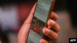 FILE - A user browses on his phone showing a candidate in the Philippines' upcoming presidential election, in Manila, March 10, 2022.