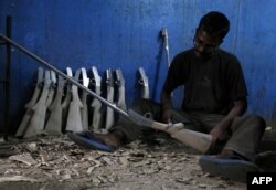 Seorang pembuat senjata India bekerja di dalam pabrik senjata di Jammu, 3 Mei 2017, di negara bagian Jammu dan Kashmir di Himalaya. (Alok PATHANIA / AFP)