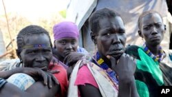 File - In this Dec. 16 2020 photo, Kallayn Keneng , foreground right, sits on the ground with three women, who all have lost chidren due to starvation when they were displaced from their villages due to fighting, in Lekuangole, South Sudan.