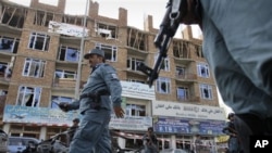 Seorang polisi Afghanistan melintasi bangunan yang digunakan sebagai basis pertahanan militan dalam serangan 18 jam di Kabul (16/4).