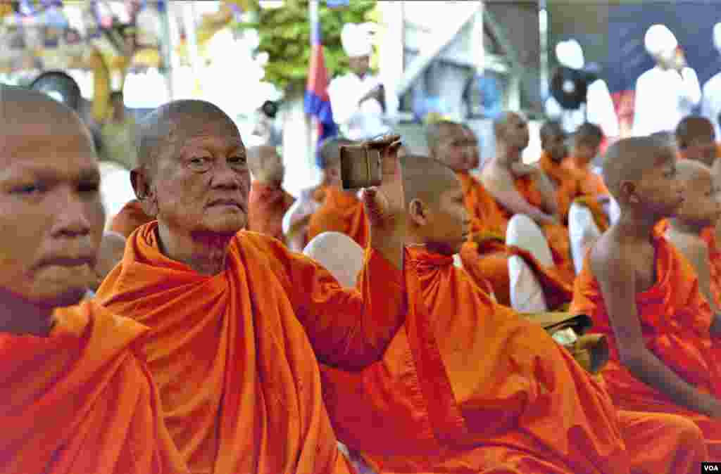 ព្រះសង្ឃប្រើប្រាស់ទូរស័ព្ទដៃ ថតផ្ដិតយកទិដ្ឋភាពពិធីរំឭកខួប៧០ឆ្នាំនៃការបាត់បង់ទឹកដីកម្ពុជាក្រោម ដែលធ្វើឡើងនៅខណ្ឌសែនសុខ រាជធានីភ្នំពេញ កាលពីថ្ងៃទី៤ ខែមិថុនា ឆ្នាំ២០១៩។ (អូន ឆេងប៉រ/VOA)